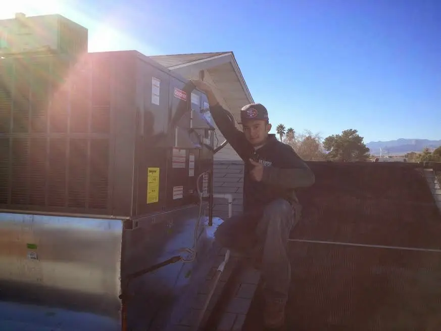 HVAC technician performing AC Tune-Up on a rooftop unit in Sudley